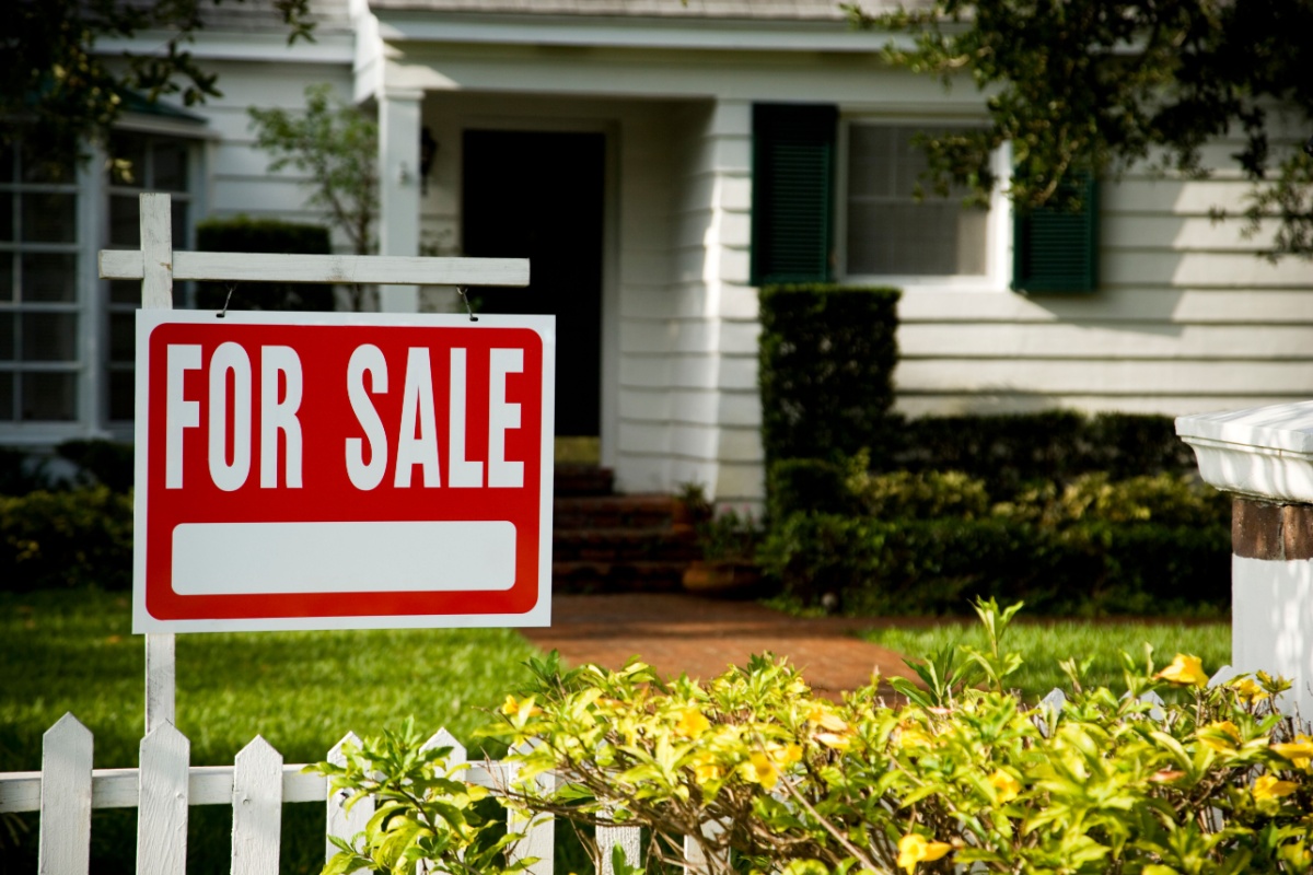 a home with a for sale sign in the yard